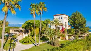 uma vista aérea de uma casa com palmeiras em LE CASTEL ROSE Super Cannes, face aux Îles de Lérins em Vallauris