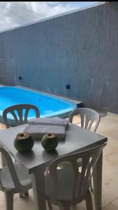 uma mesa com duas melancias ao lado de uma piscina em Casa préa kite em Cruz