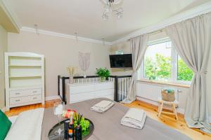 a living room with a bed and a window at Apartamenty Colobrzeg Sweet Home in Kołobrzeg