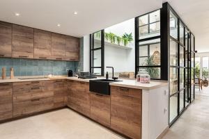 Una cocina con gabinetes de madera y un fregadero. en Ocean beachside house with pool, en Conil de la Frontera