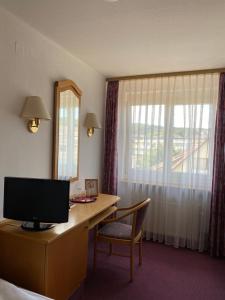 a hotel room with a desk with a computer and a window at Hotel-Restaurant Zum Loewen in Jestetten