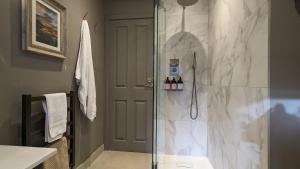 a bathroom with a shower with a glass door at The Posting House in Kilchrenan +37 photos