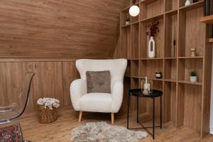 a living room with a white chair and a table at GO Jahorina by Olympic Gardens in Jahorina