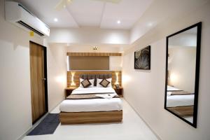 a bedroom with two beds and a mirror at HOTEL ALFA EXECUTIVE in Mumbai