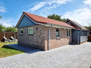 een stenen huis met een rood dak op een oprit bij Sfeervol vakantiehuis Oostkapelle OK16 in Oostkapelle