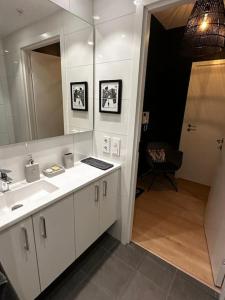 La salle de bains est pourvue d'un lavabo et d'un miroir. dans l'établissement Stunning studio with ocean view, à Kristiansand