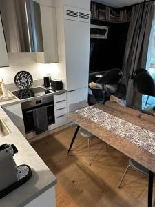 Il comprend une cuisine équipée d'une table, de chaises et d'une cuisinière. dans l'établissement Stunning studio with ocean view, à Kristiansand