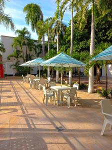 a group of tables and chairs with umbrellas at Vajamar Hotel in Valledupar