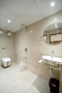 a bathroom with a sink and a toilet and a mirror at HOTEL ALFA EXECUTIVE in Mumbai