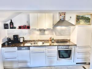 a kitchen with white cabinets and a sink at VIEW4TWO / Chalet-Apartment Zillertal in Hart im Zillertal