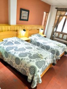 duas camas sentadas uma ao lado da outra num quarto em Cittadella Hostal em Sucre