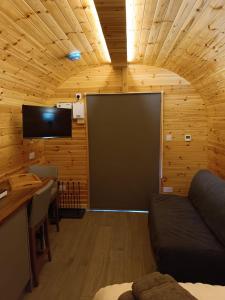 a living room with a large screen in a wooden room at Aurora Skye in Breakish