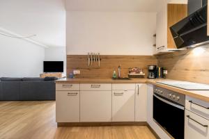 eine Küche mit weißen Schränken und ein Wohnzimmer in der Unterkunft Hodderup Wohnung 10 in Husby