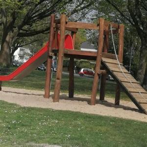 einen Spielplatz mit einer roten Rutsche in einem Park in der Unterkunft Relax Aachener Boardinghouse Budget in Aachen