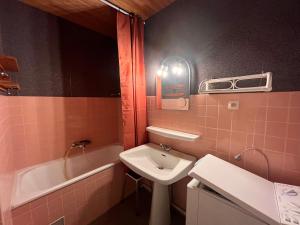 ein rosafarbenes Badezimmer mit einem Waschbecken und einer Badewanne in der Unterkunft Studio Les Sables-d'Olonne, 1 pièce, 4 personnes - FR-1-197-431 in Les Sables-dʼOlonne