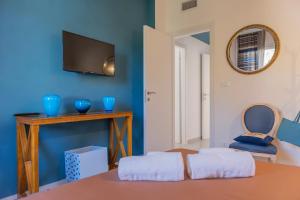 uma sala de estar com televisão e uma parede azul em Gerani Apartments em Bordighera