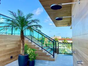 a staircase with a palm tree in a house at Green Porto 207 -Flat premium no centro de Porto in Ipojuca