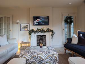 a living room with a fireplace with a tv above it at The Posting House in Kilchrenan