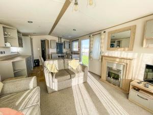 a living room with a couch and a fireplace at Beautiful Caravan At Manor Park Nearby Hunstanton Beach Ref 23030w in Hunstanton
