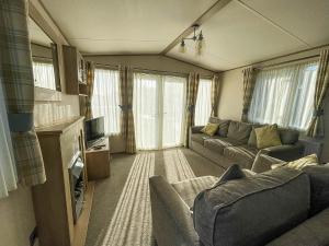 uma sala de estar com um sofá e uma televisão em Beautiful Caravan At Manor Park Nearby Hunstanton Beach Ref 23030w em Hunstanton