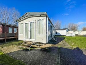 una casita blanca pequeña sentada en un patio en Beautiful Caravan At Manor Park Nearby Hunstanton Beach Ref 23030w en Hunstanton