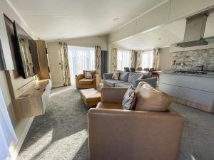 een woonkamer met 2 banken en een keuken bij Stunning Lodge With Decking Nearby Hunstanton Beach, Sleeps 6 Ref 23215k in Hunstanton