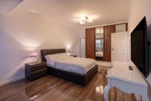 Dormitorio con cama, escritorio y TV en Beachfront Penthouse , Roof Balcony With Sea View, Free Use of Hotel's Spa, Sauna, Gym and Pool en Brighton & Hove