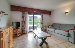 uma sala de estar com um sofá, uma televisão e uma mesa em Awesome Apartment In Bredene With Heated Swimming Pool em Bredene