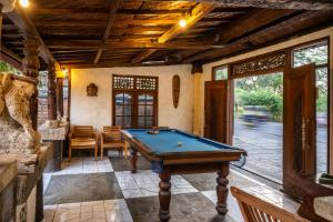 a pool table in the middle of a room at Lombok Stanley Garden Villas in Montongbuwoh