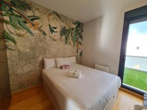 um quarto com uma grande cama branca e um mural em Ático de Lujo en el Centro de Burgos em Burgos
