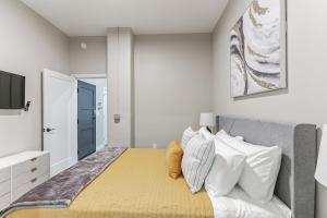 a bedroom with a large bed with white pillows at Downtown Stroll to the Bengals in Cincinnati