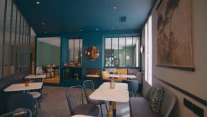 ein Restaurant mit Tischen und Stühlen und einem Kamin in der Unterkunft Best Western Hotel du Pont Wilson in Lyon