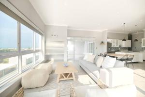 ein Wohnzimmer mit einem weißen Sofa und einem Tisch in der Unterkunft Alwil Ocean View Villas - Unit 5 in Struisbaai
