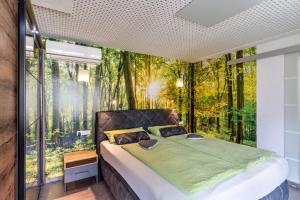 a bedroom with a bed in a forest mural at Azuria Schwarzwald Loft in Kappelrodeck
