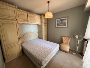 um quarto com uma cama, um armário e uma cadeira em Appartement Les Sables-d'Olonne, 2 pièces, 4 personnes - FR-1-197-466 em Les Sables-dʼOlonne