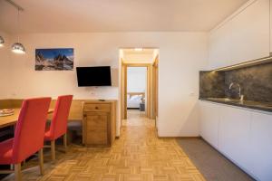 a room with a kitchen and a table with chairs at Rosalpina Apt 4 in San Vigilio Di Marebbe