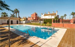 a large swimming pool in a yard with houses at Gorgeous Apartment In Sanlcar De Barrameda With Wifi in Sanlúcar de Barrameda
