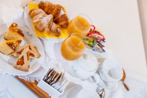 une table avec des assiettes de nourriture, des tasses et du pain dans l'établissement Hotel Costa Caddu, à San Teodoro