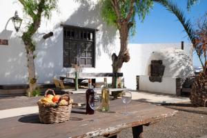 un tavolo da picnic con cesto di frutta e bottiglie di vino di Finca Emblemática - Nº3 Liria a La Vegueta