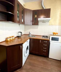 uma cozinha com um lavatório e uma máquina de lavar roupa em Бакулина 14 em Kharkov