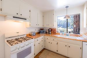 a kitchen with white cabinets and a stove top oven at The Redwood Sanctuary in Monte Rio