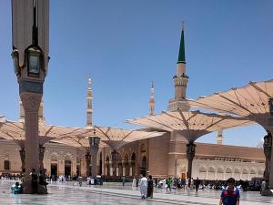 a large building with a mosque with a tall tower at فندق رؤيا الاندلس النخبة - Roaya Alandalus Elite Hotel in Medina