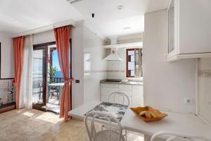 een witte keuken met een tafel en stoelen en een balkon bij Apartamento el descanso in Candelaria