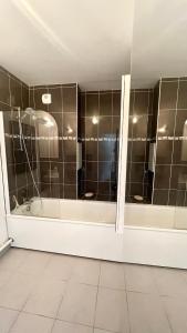 a bathroom with a tub and a large shower at L'Ecrin - Charmant logement entre Paris & Disney in Champigny-sur-Marne