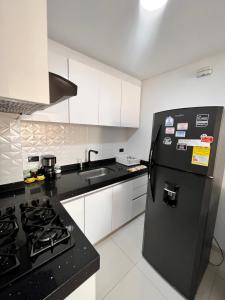 a kitchen with a black refrigerator and a sink at Apartamento en Cartago in Cartago
