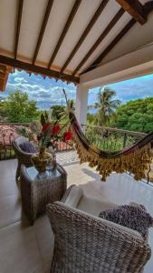 a balcony with wicker chairs and a hammock at El Hotel De La Tía in San Bernardo del Viento