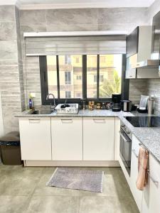 a kitchen with white cabinets and a sink and a window at luxury suites CHESTER ONE in Dakar