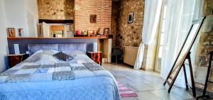 1 dormitorio con 1 cama en una habitación con una pared de ladrillo en Gîte en Lot-et-Garonne avec piscine et jardin de 6000m2, en Bourran