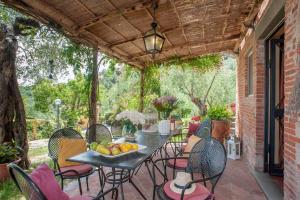 un patio con una mesa y sillas con fruta. en Romantic farmhouse villa Pallina to sleep 5 guests, en Aquilea