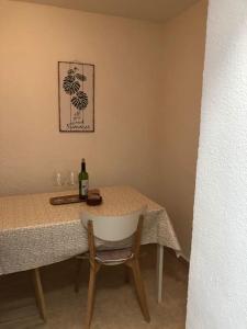 a table with a white chair and a bottle of wine at Casa Vincent, 350 m tot strand, airco in Villajoyosa